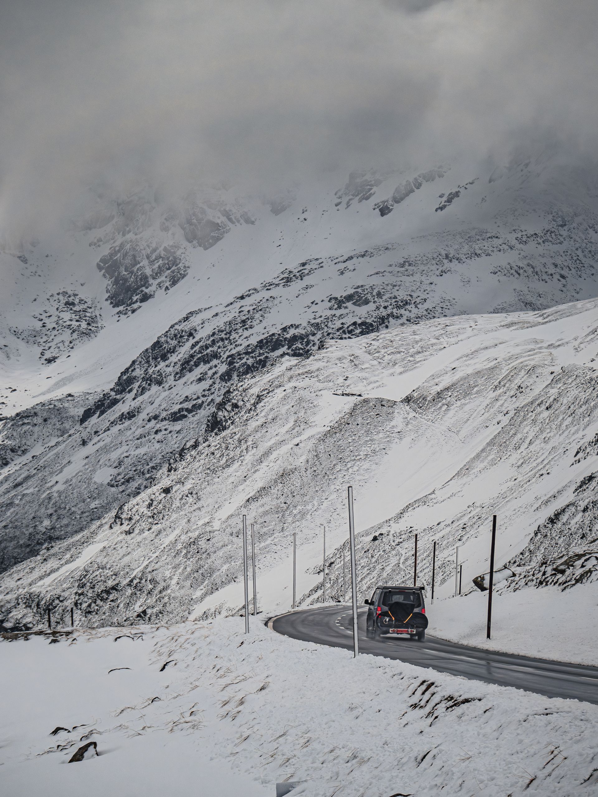 A car on a snowy Swiss alpine mountain pass